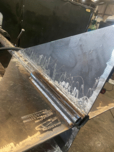 Custom fabricated bracing bar primed and painted - close up of fins