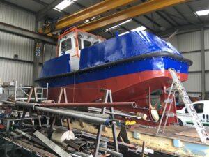 Side view of a boat in for repair and re-painting with Hickman Engineering